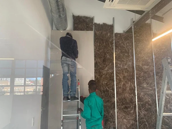 Acoustic insulation fitted within a drywall partition during installation